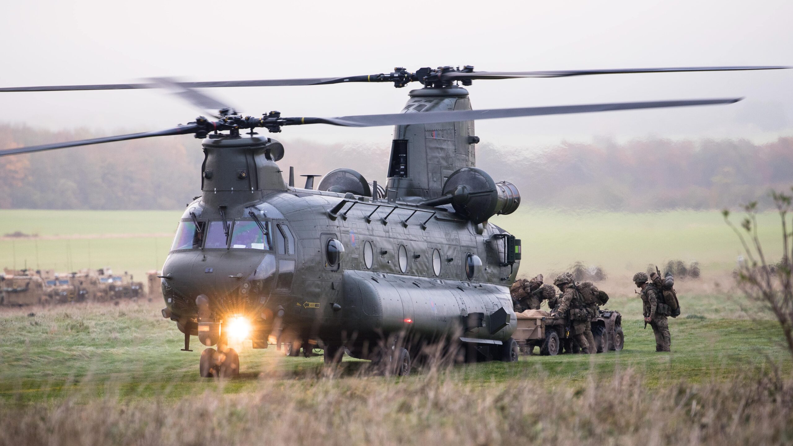 Military helicopter with troops standing around