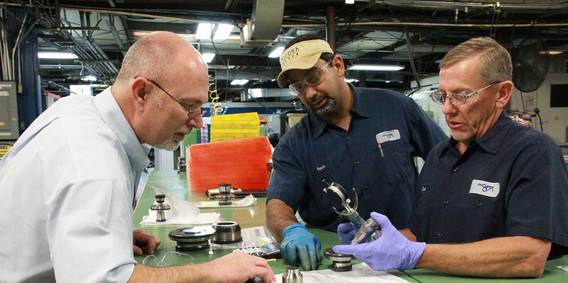 Employees inspecting a die